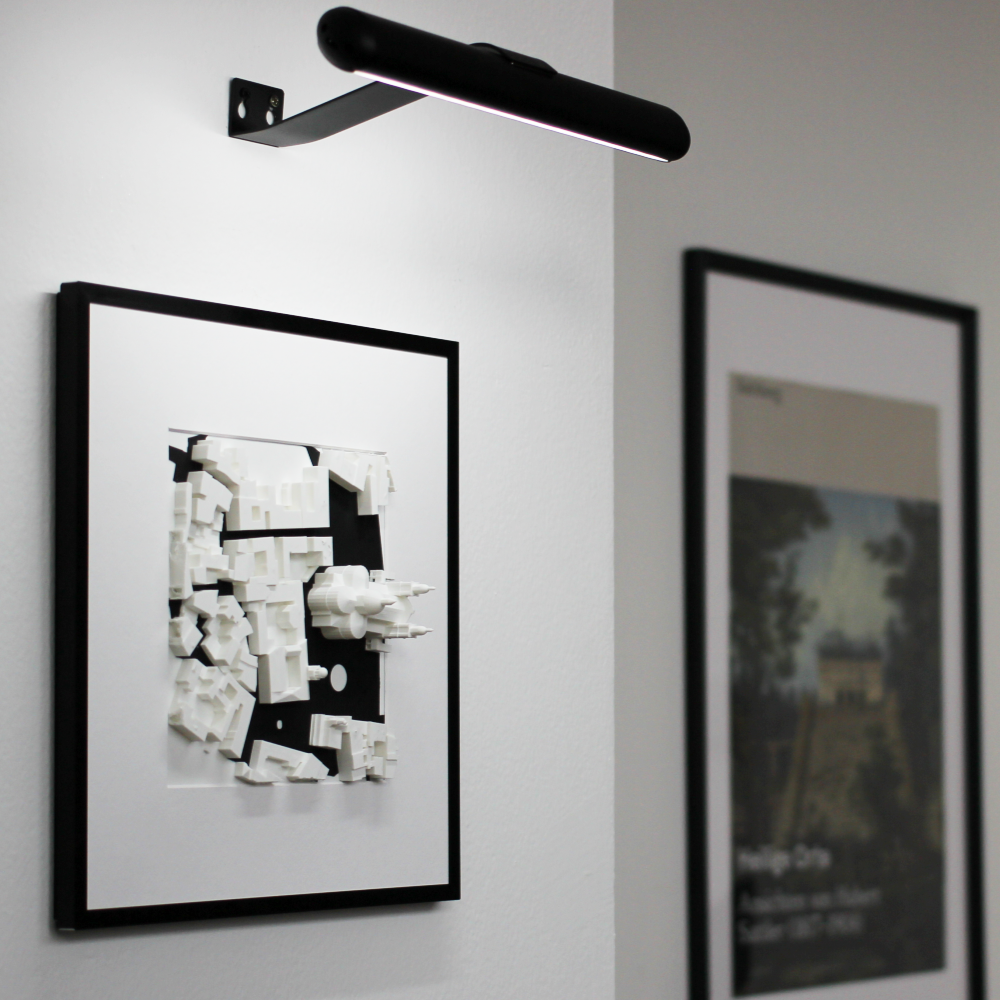 Urban 3D artwork on a wall with a light fixture above.